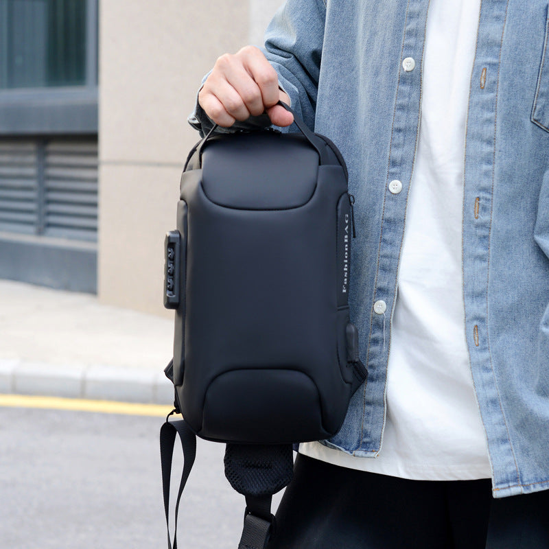 Person holding a dark combination lock chest bag by its top handle