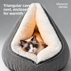 Front view of gray cat cave bed with white plush entrance and a blue-eyed cat
